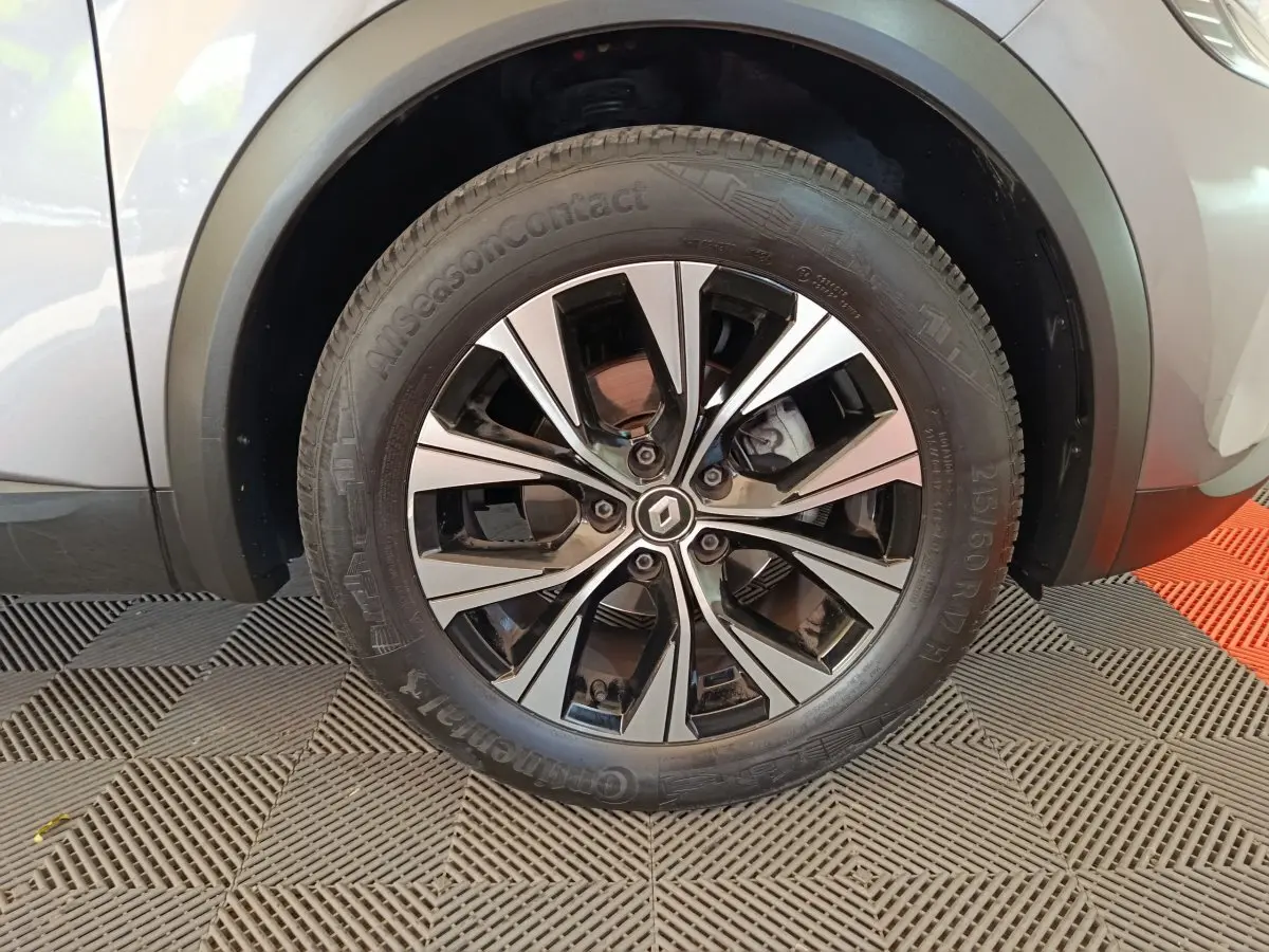 Gros plan sur la roue avant droite du Renault Captur gris foncé, mettant en valeur la jante alliage au design moderne.