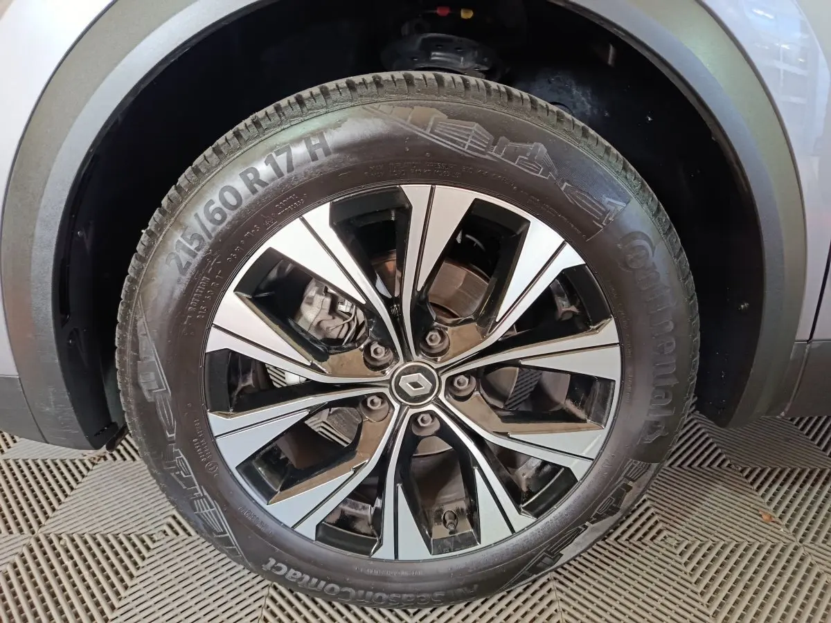 Gros plan sur la roue avant gauche du Renault Captur gris foncé, mettant en valeur la jante alliage moderne et le pneu Continental.