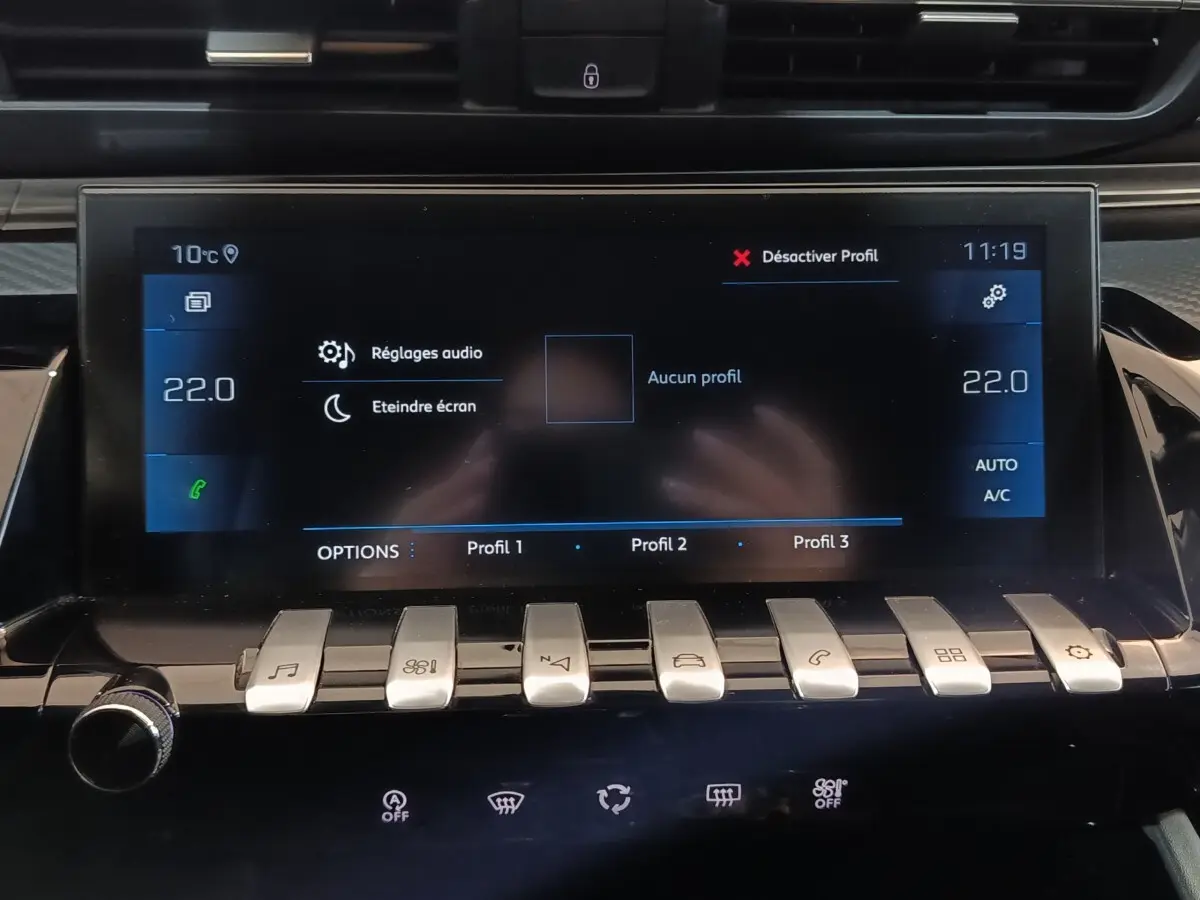 Vue rapprochée de l’écran tactile central et des commandes en métal brossé du tableau de bord d’une Peugeot 508 gris clair.