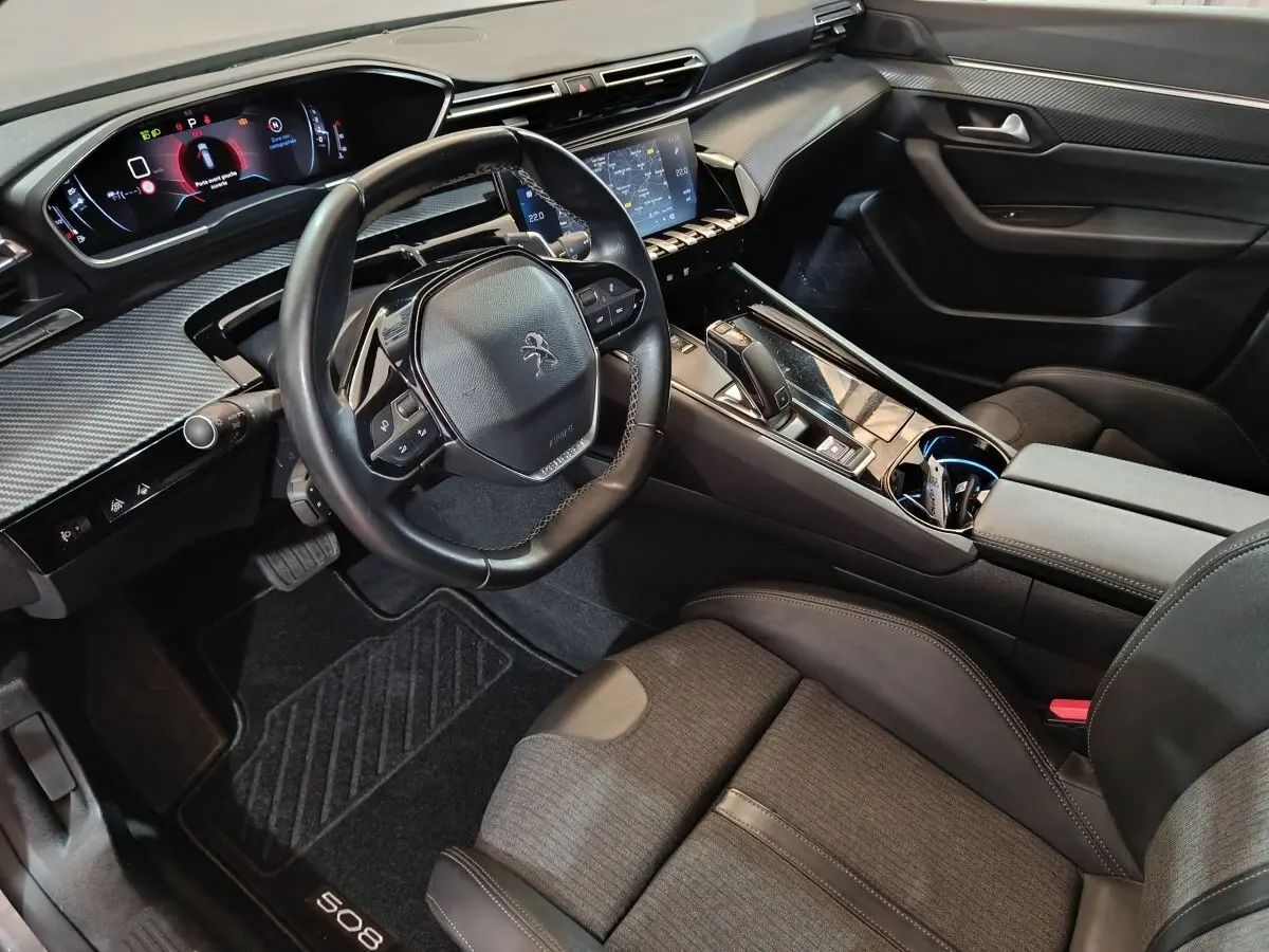 Vue intérieure côté conducteur de la Peugeot 508 2020, tableau de bord numérique et volant cuir noir avec console centrale moderne.