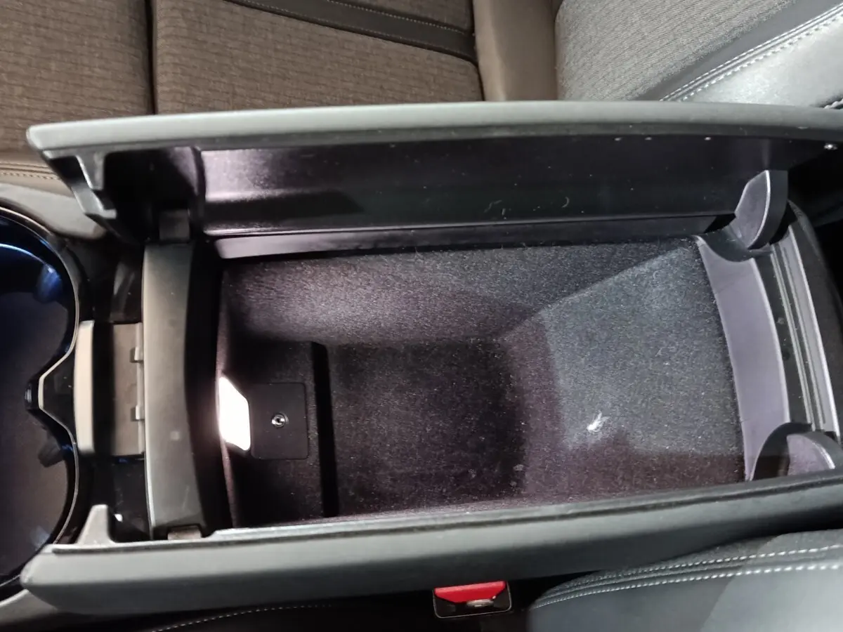 Vue rapprochée de la console centrale ouverte avec rangement intérieur noir du Peugeot 508 gris clair 2020.