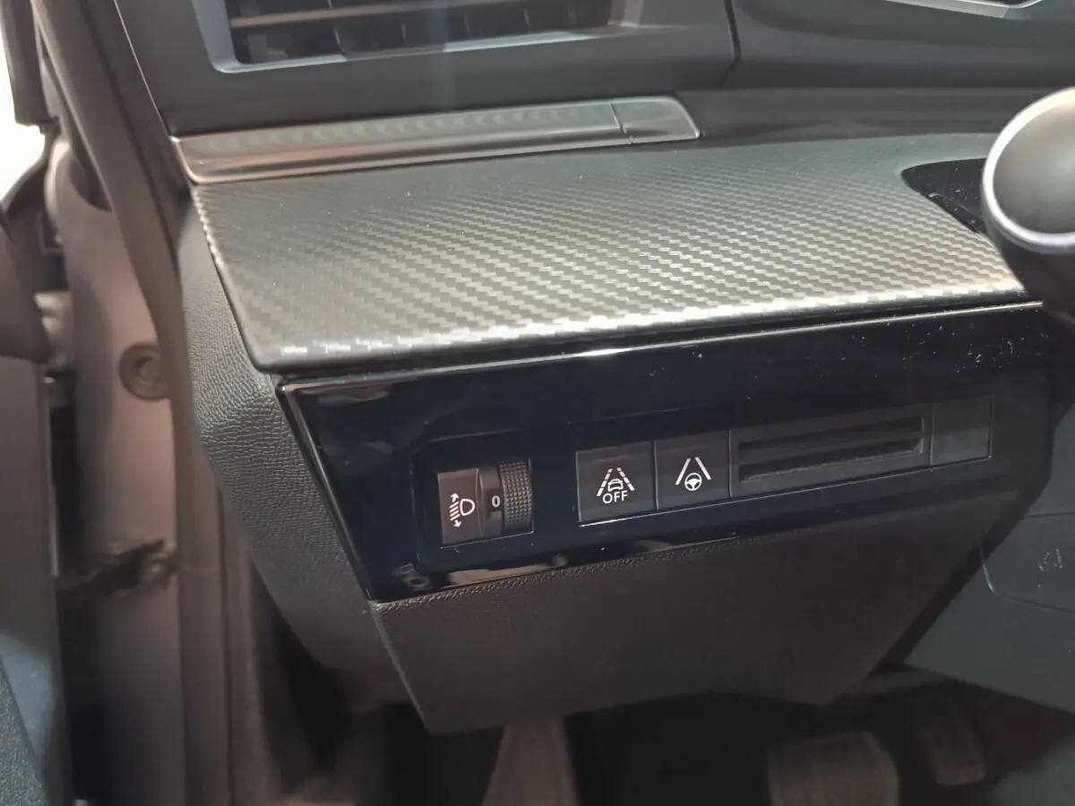 Détail du tableau de bord côté gauche avec commandes d’éclairage et d’aide à la conduite sur Peugeot 508 gris clair 2020.