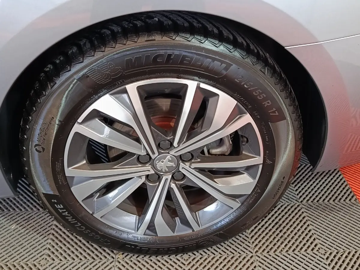 Gros plan sur la roue avant gauche gris clair d'une Peugeot 508 BlueHDi 130 avec jante alliage et pneu Michelin.