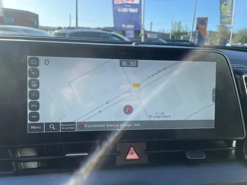 Écran tactile du système de navigation du Kia Sportage 2023, affichant une carte avec indication de position et heure 16h30.