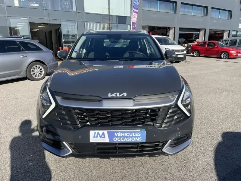 Vue avant d’un KIA Sportage gris Eclipse Metal 2023 avec calandre noire et logo KIA moderne visible.