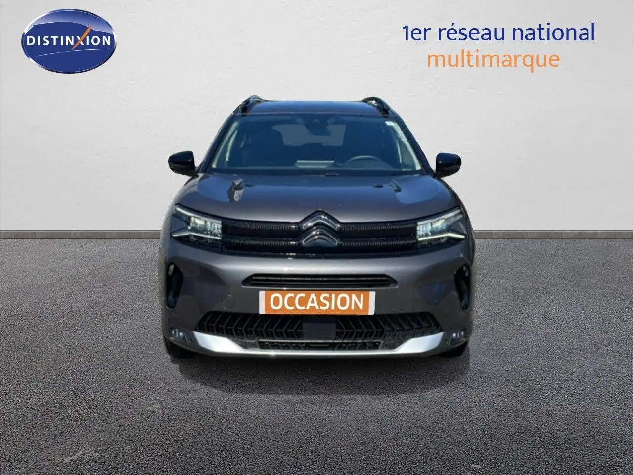 Vue frontale d'un Citroën C5 Aircross gris platinium métal avec calandre noire et feux LED allumés.