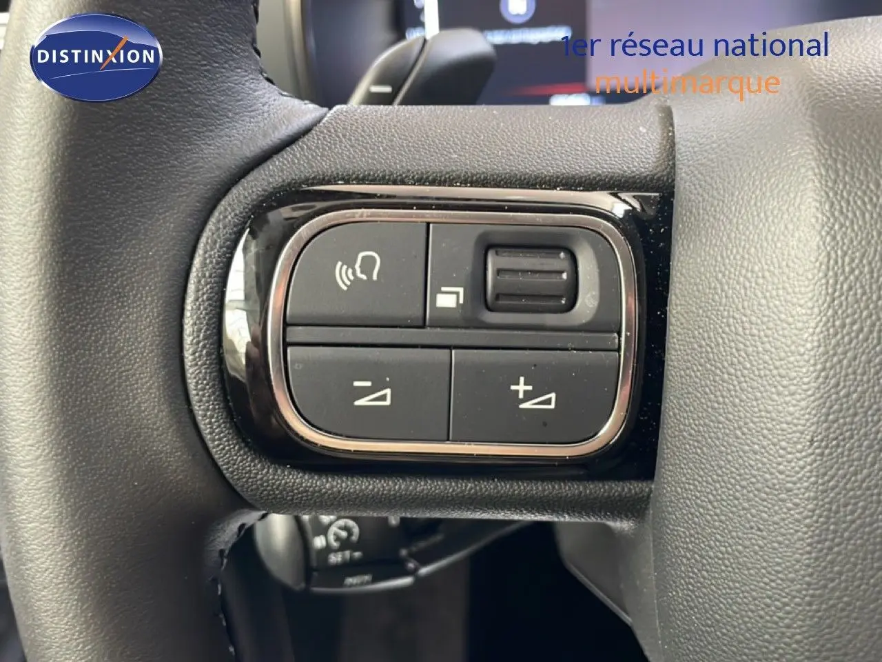 Gros plan sur les commandes de volume et téléphone sur le volant du Citroën C5 Aircross gris platinium 2025.