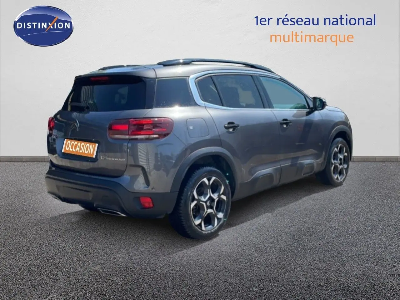 Vue 3/4 arrière droite d'un Citroën C5 Aircross gris platinium métal avec jantes bi-ton et toit panoramique.