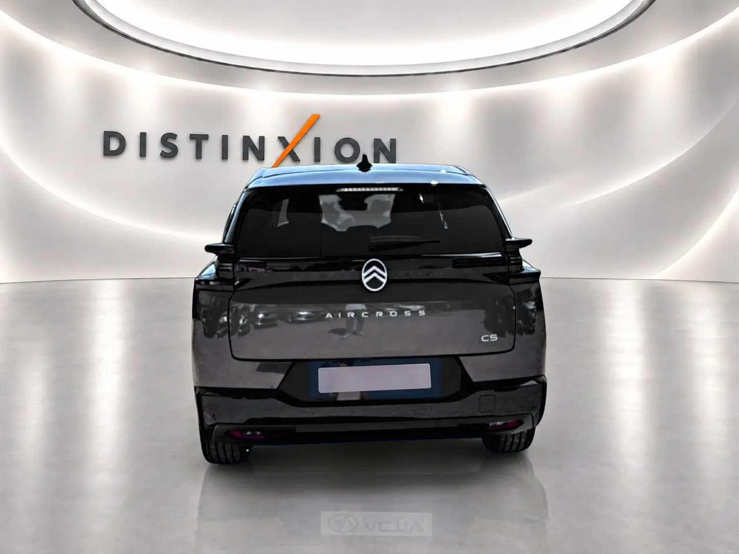 Vue arrière d'un Citroën C5 Aircross gris platinium avec toit noir dans un showroom lumineux Distinxion.