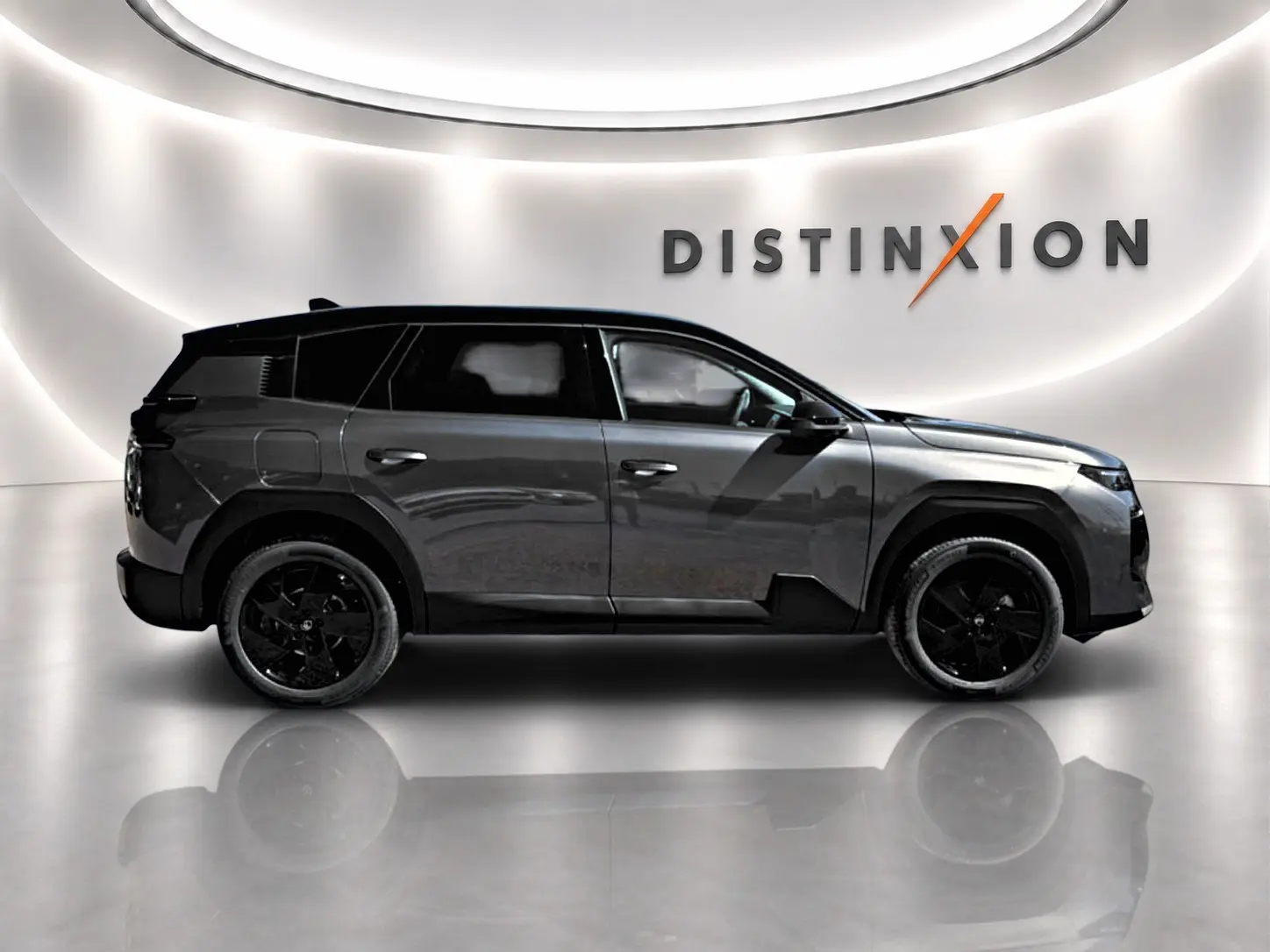 Vue latérale droite d'un Citroën C5 Aircross gris platinium avec toit noir et jantes alliage noires dans un showroom.