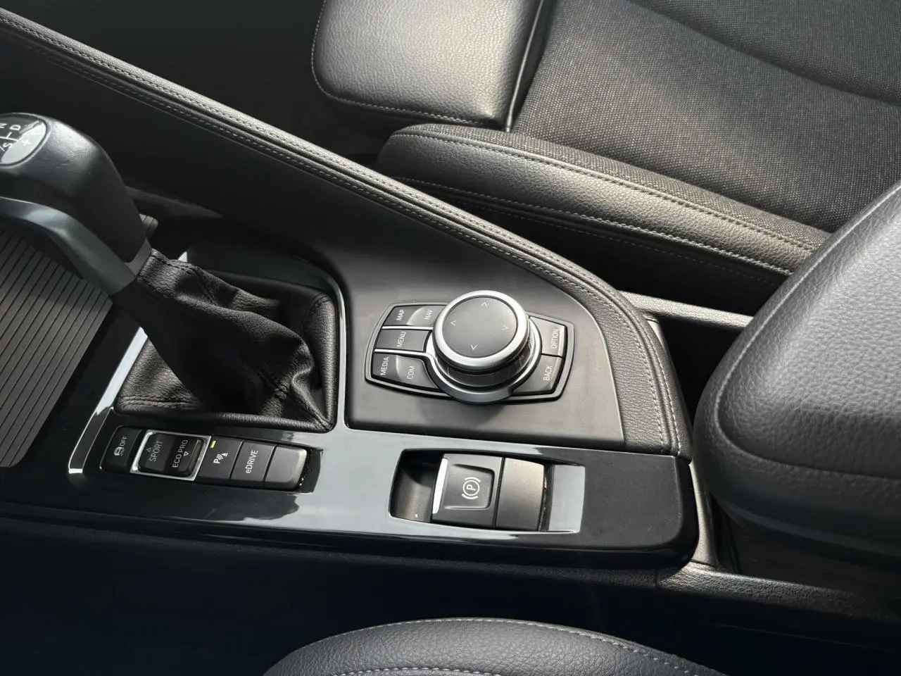 Vue rapprochée de la console centrale noire avec levier de vitesses et commandes du BMW X2 F39 Or Galvanic.