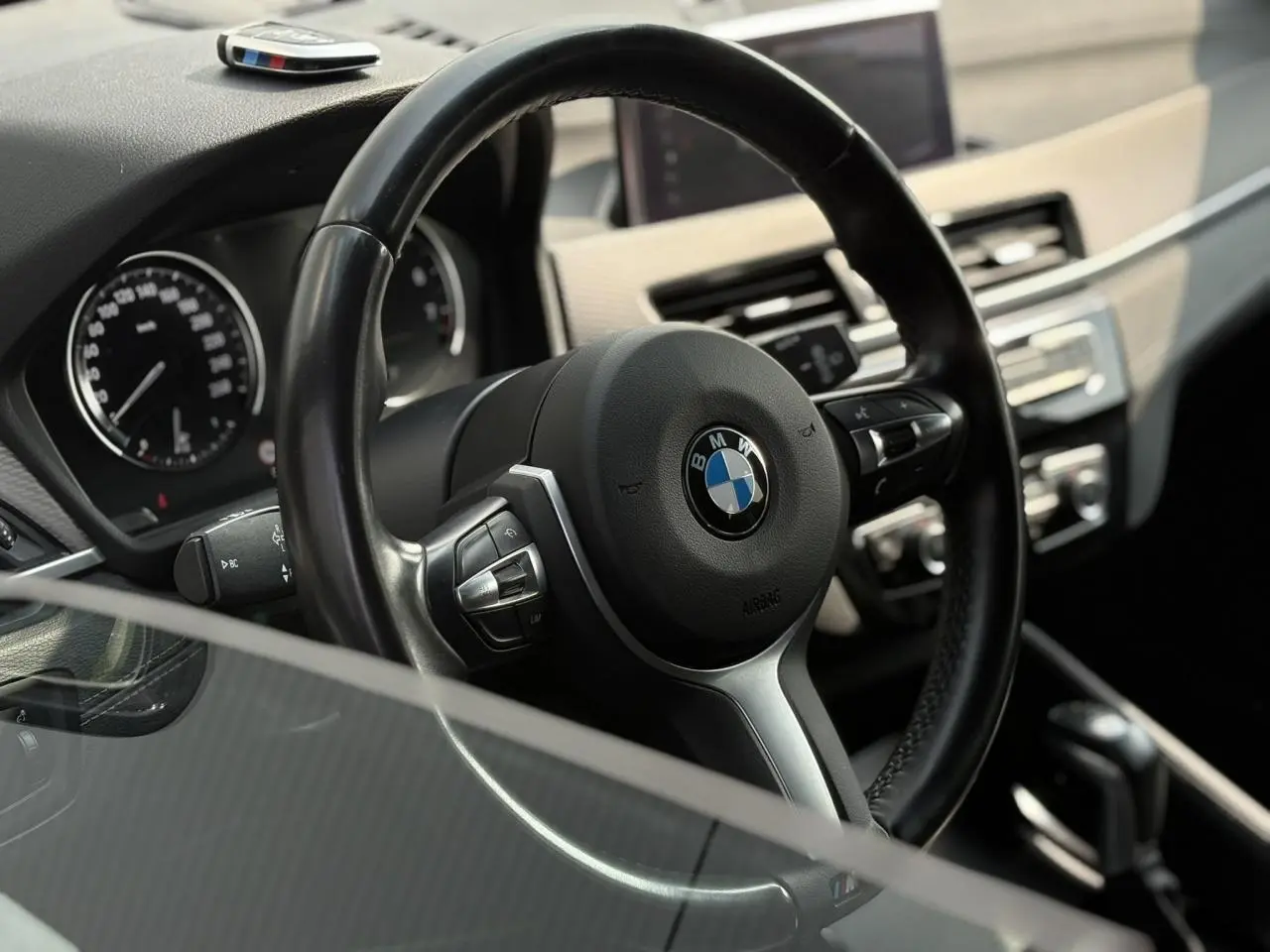 Vue rapprochée du volant cuir M et tableau de bord du BMW X2 F39 avec commandes multifonctions et écran GPS.