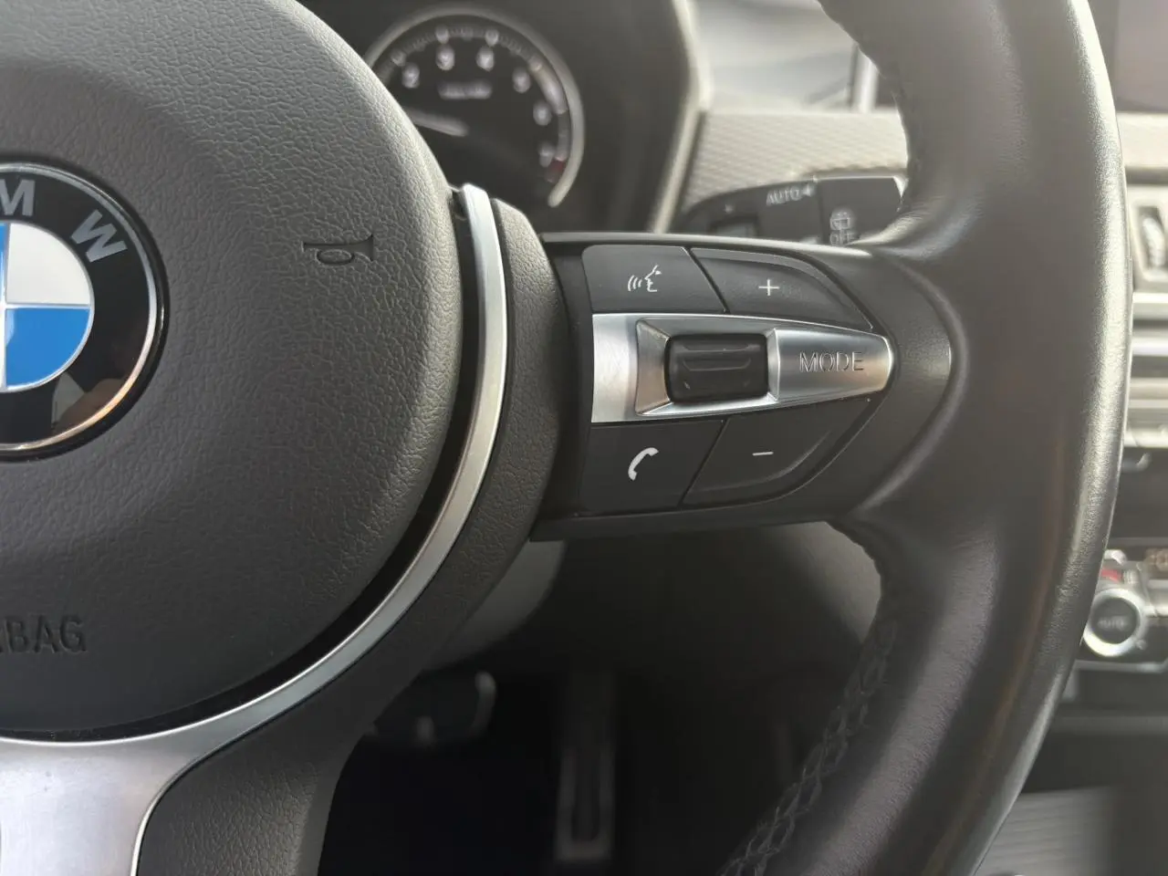 Gros plan sur le volant cuir M de la BMW X2 F39, mettant en valeur les commandes multifonctions côté droit.