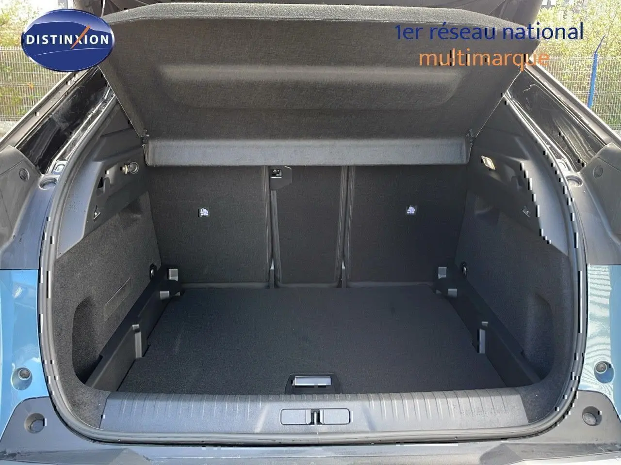 Coffre ouvert du Peugeot 3008 bleu Ingaro métal avec toit noir, vue arrière montrant l'espace de chargement vide.