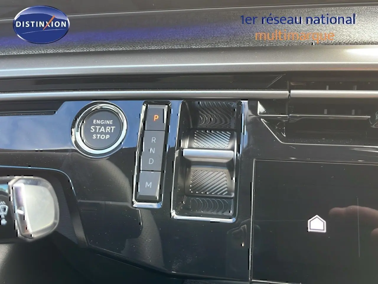 Gros plan sur la console centrale noire brillante du Peugeot 3008 hybride 2025 avec bouton start/stop et sélecteur de boîte automatique.