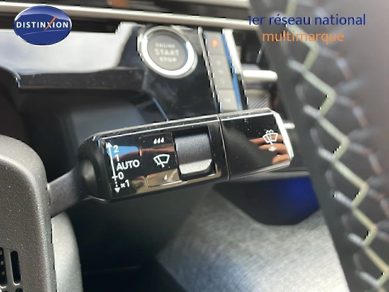 Gros plan sur la commande d'essuie-glace du Peugeot 3008 2025, intérieur noir avec bouton start visible en arrière-plan.