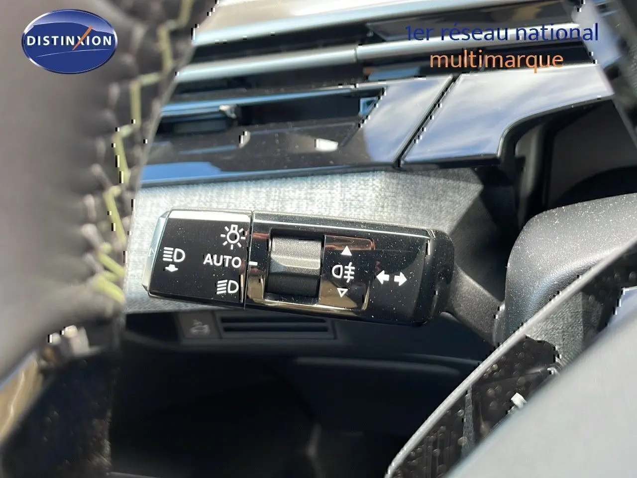 Le levier de commande des feux et clignotants du Peugeot 3008 hybride 2025, avec tableau de bord en arrière-plan.