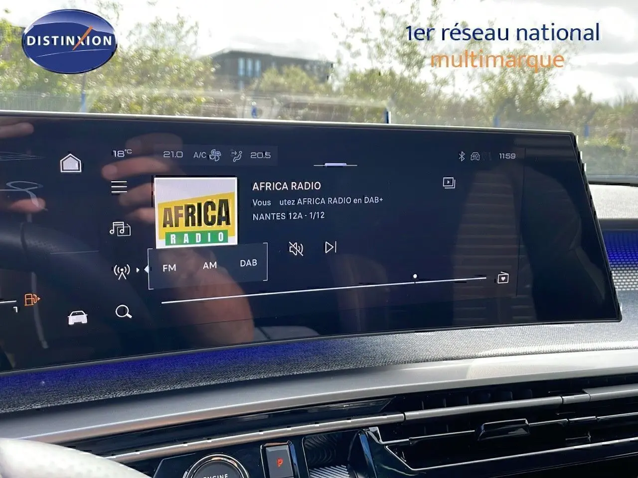 Écran tactile central affichant la radio Africa Radio dans le Peugeot 3008 hybride 2025, intérieur moderne et lumineux.