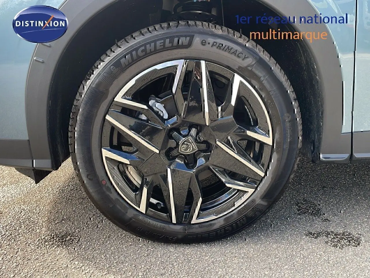 Gros plan sur la roue avant gauche du Peugeot 3008 bleu Ingaro métal avec jante alliage noire et argentée.