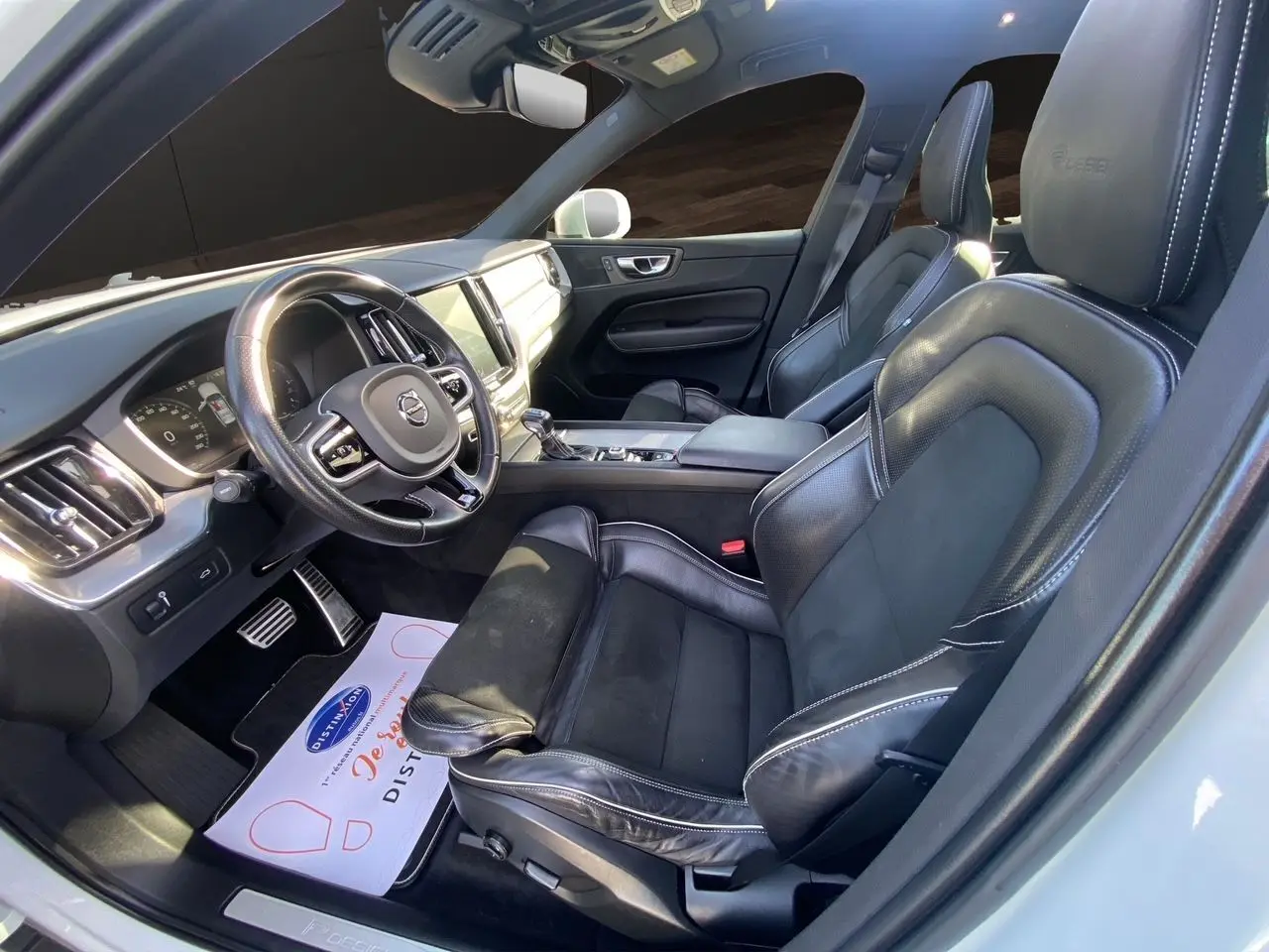 Intérieur noir cuir du Volvo XC60 D4 2019 vu côté conducteur, avec volant multifonction et tableau de bord moderne.