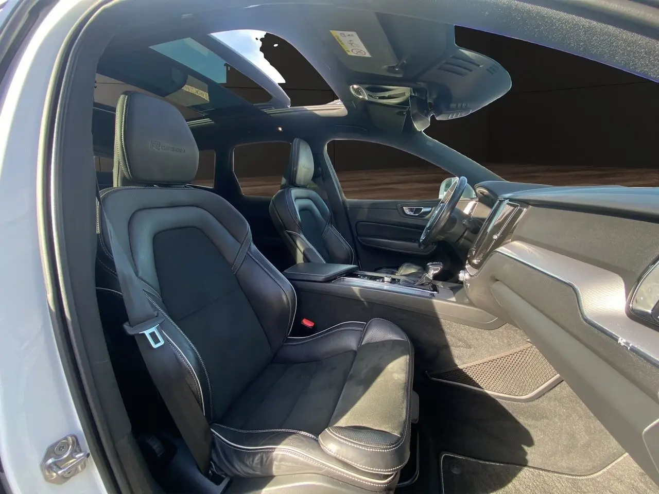 Intérieur noir du Volvo XC60 D4 2019 en vue latérale gauche, sièges R-Design en cuir avec toit ouvrant panoramique.