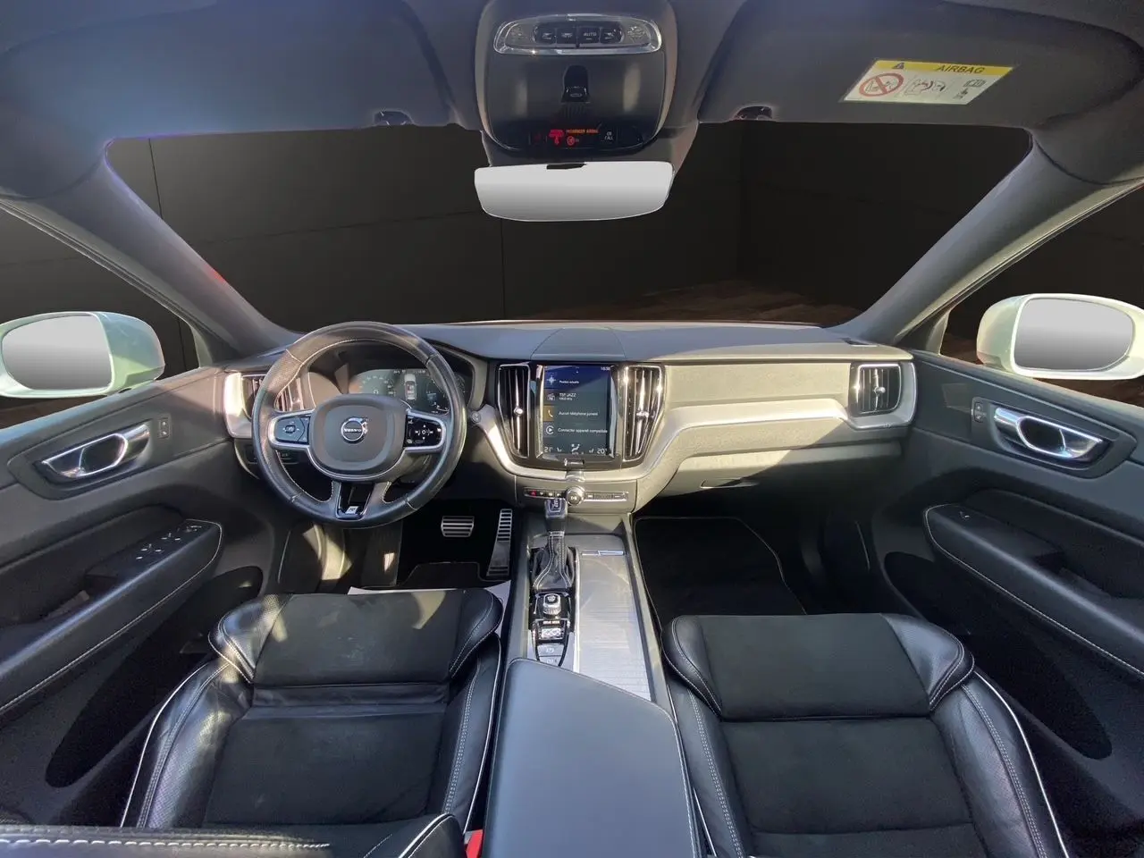 Intérieur noir cuir du Volvo XC60 D4 2019 vu de face, montrant tableau de bord et volant multifonction.