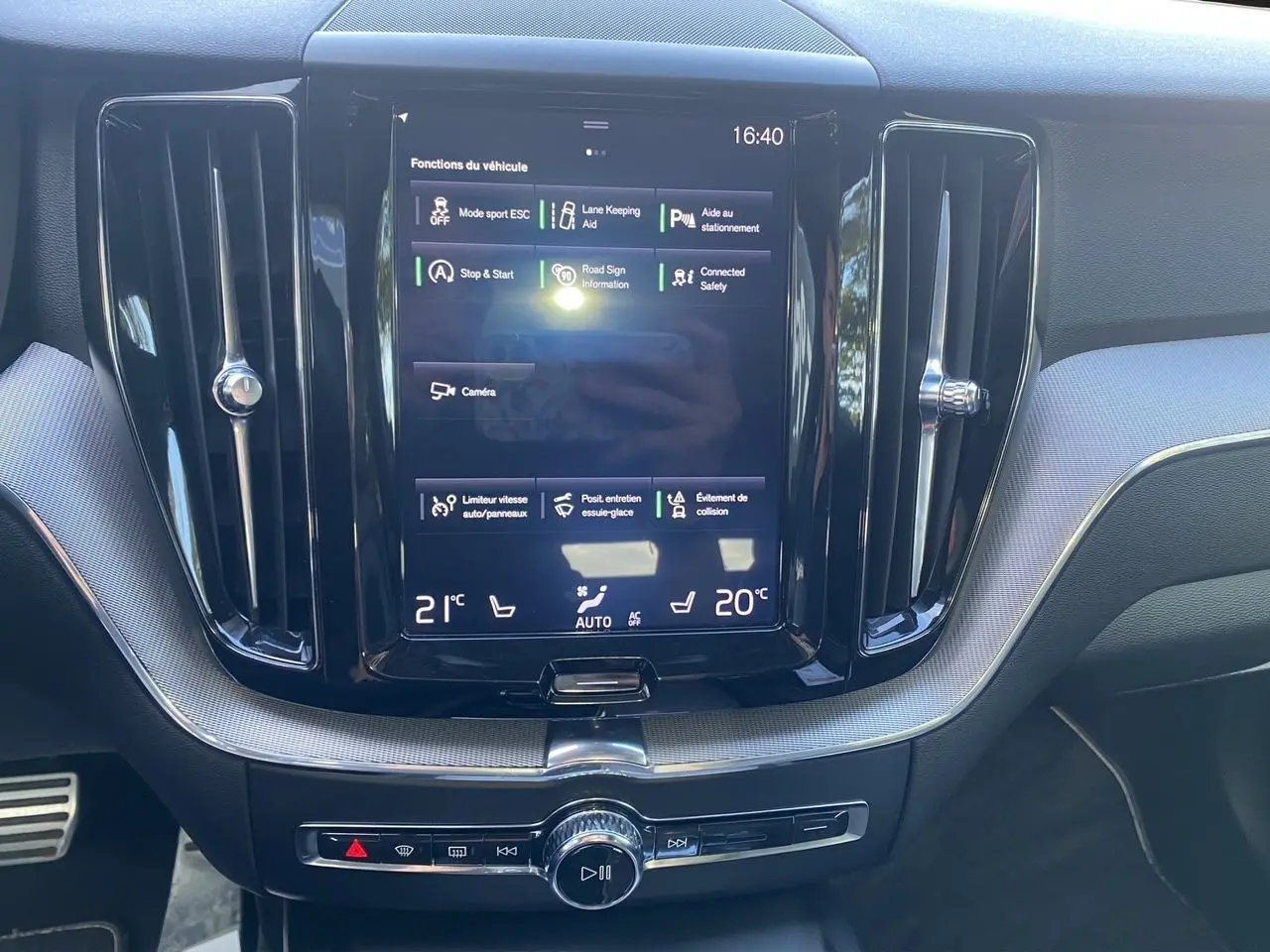 Écran tactile central du tableau de bord du Volvo XC60 blanc 2019, affichant les fonctions d'aide à la conduite.