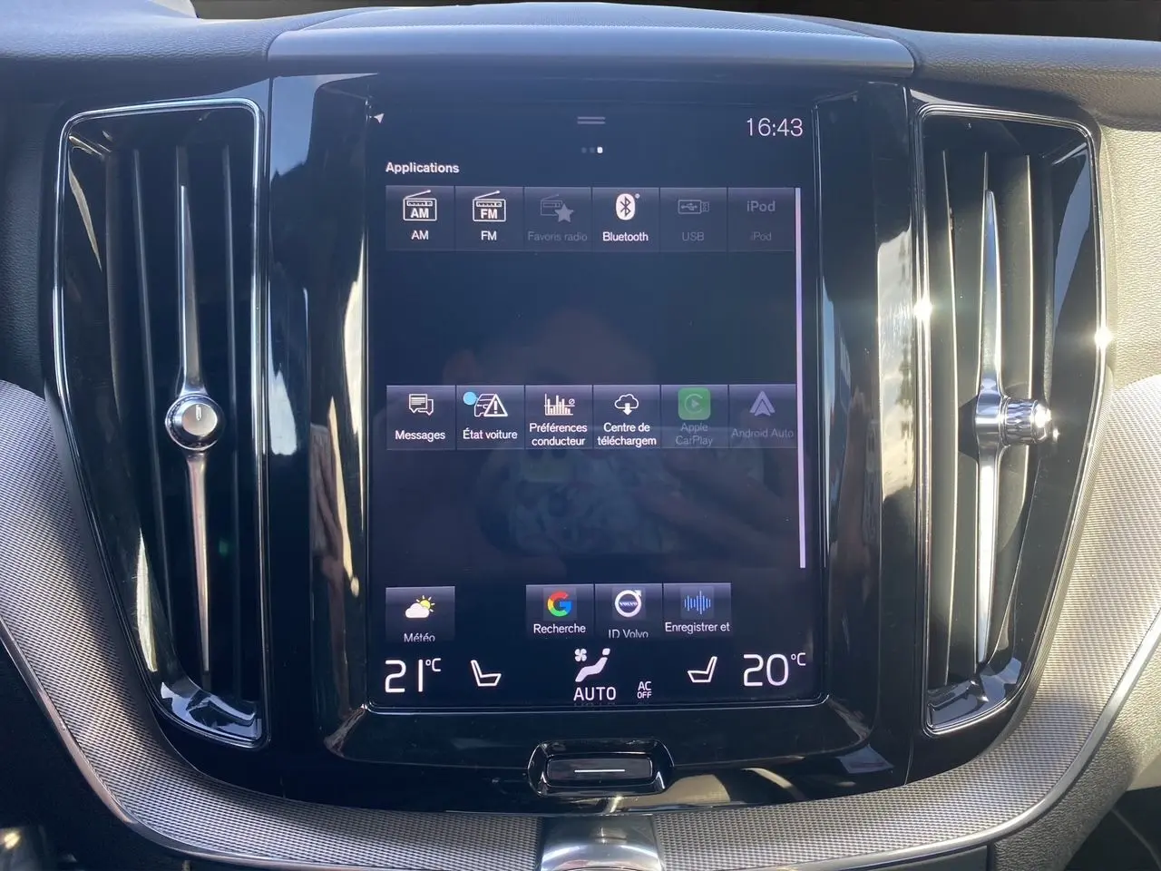 Écran tactile central du tableau de bord du Volvo XC60 blanc 2019, avec commandes climatisation et ventilation visibles.