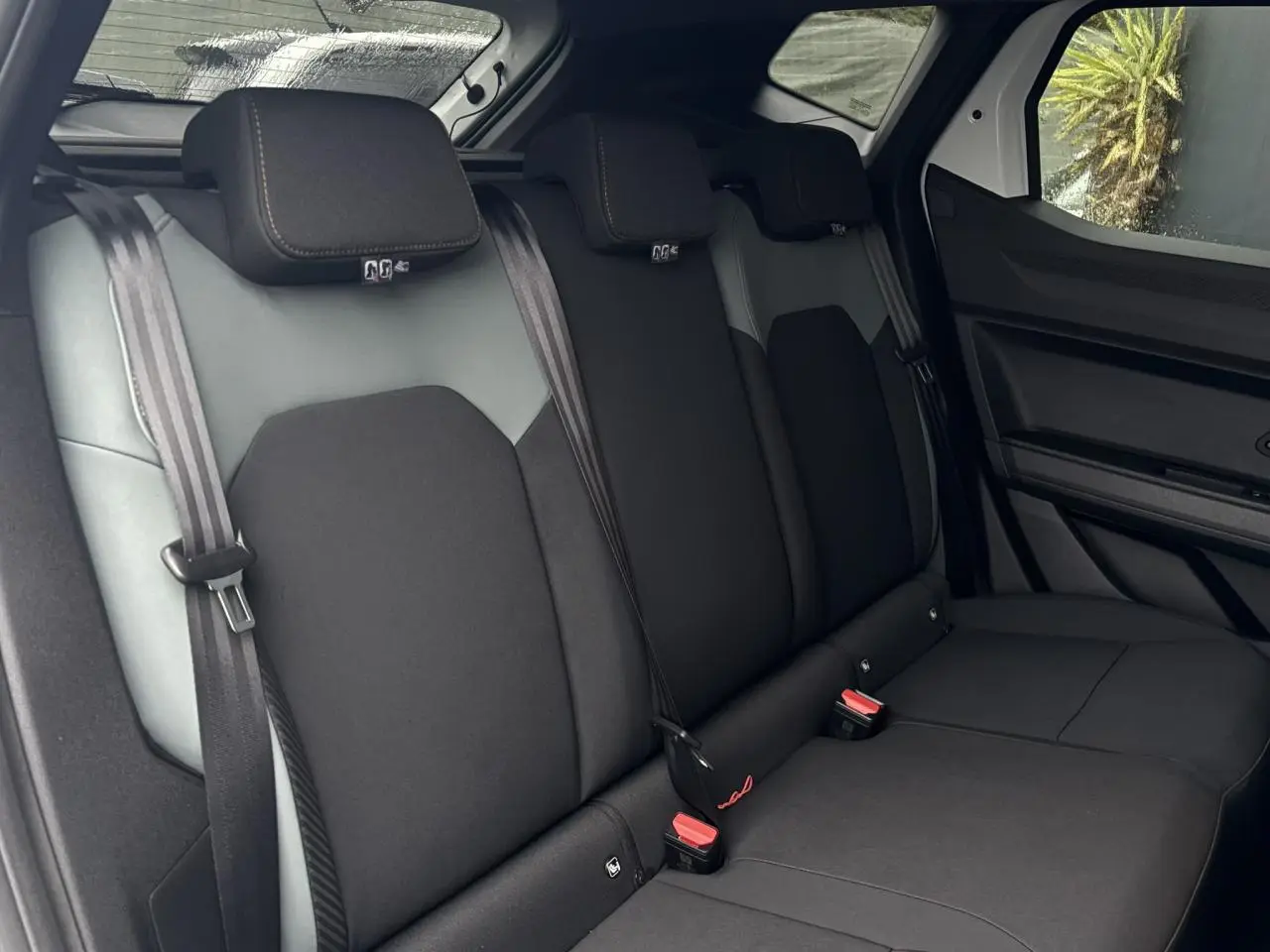 Vue intérieure sur la banquette arrière noire du Dacia Duster 2026, avec ceintures de sécurité et appuie-têtes visibles.