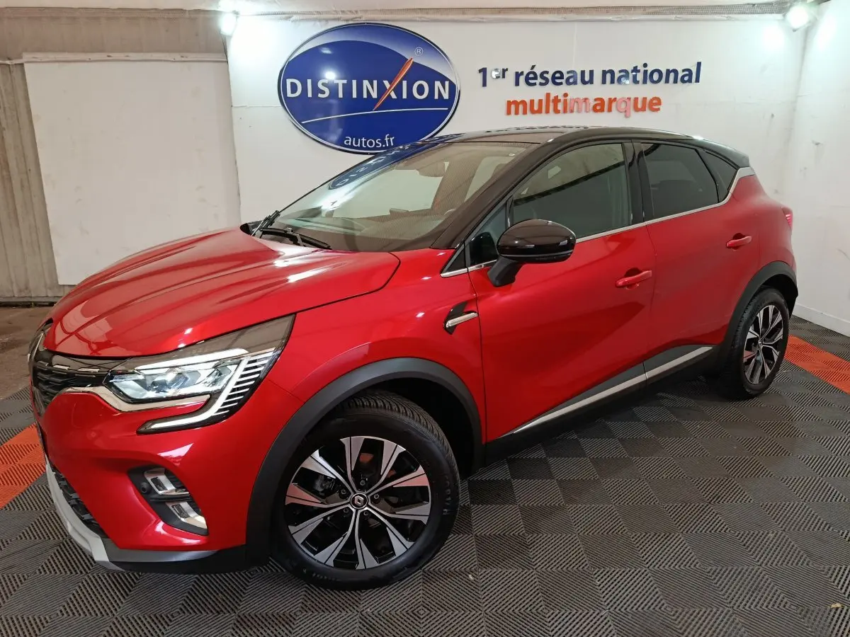 Renault Captur Techno TCe 90 rouge vue 3/4 avant droit en intérieur avec toit noir et jantes alliage.