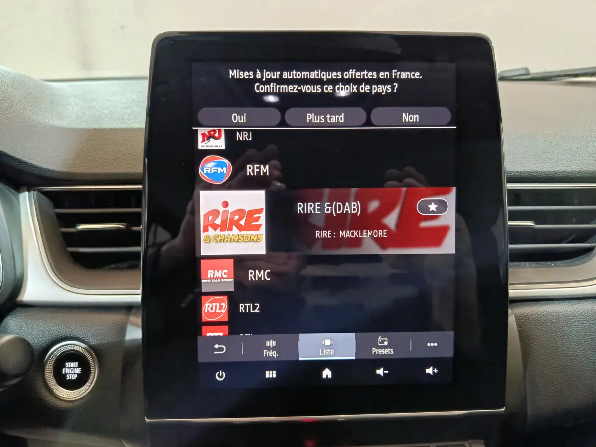 Écran tactile central du tableau de bord du Renault Captur Techno TCe 90 affichant la liste radio, bouton démarrage visible à gauche.