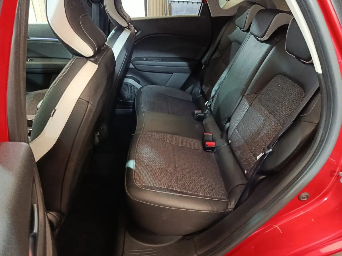 Vue côté gauche sur la banquette arrière noire et tissu du Renault Captur techno TCe 90 rouge 2024.