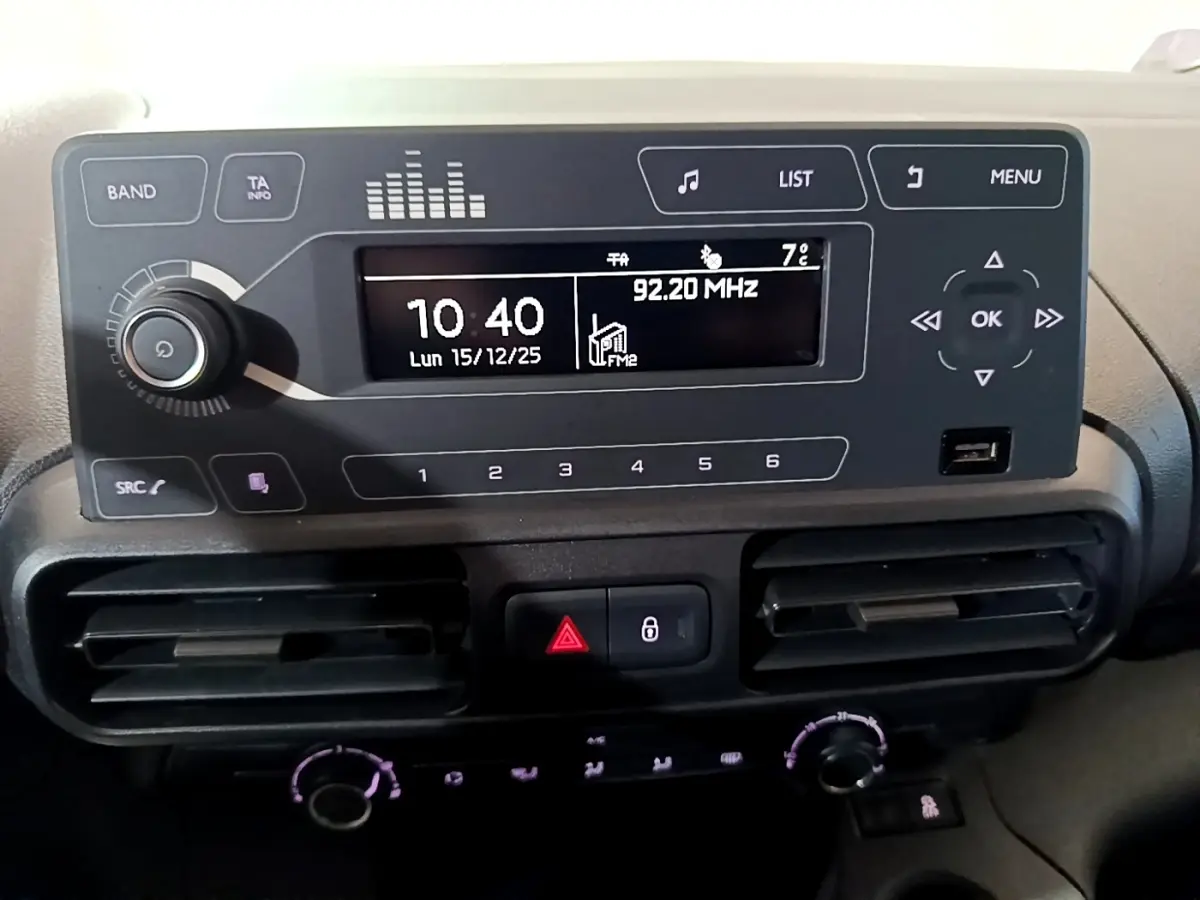 Vue rapprochée du tableau de bord noir du Citroën Berlingo XL blanc, affichant l’écran radio et les commandes climatisation.