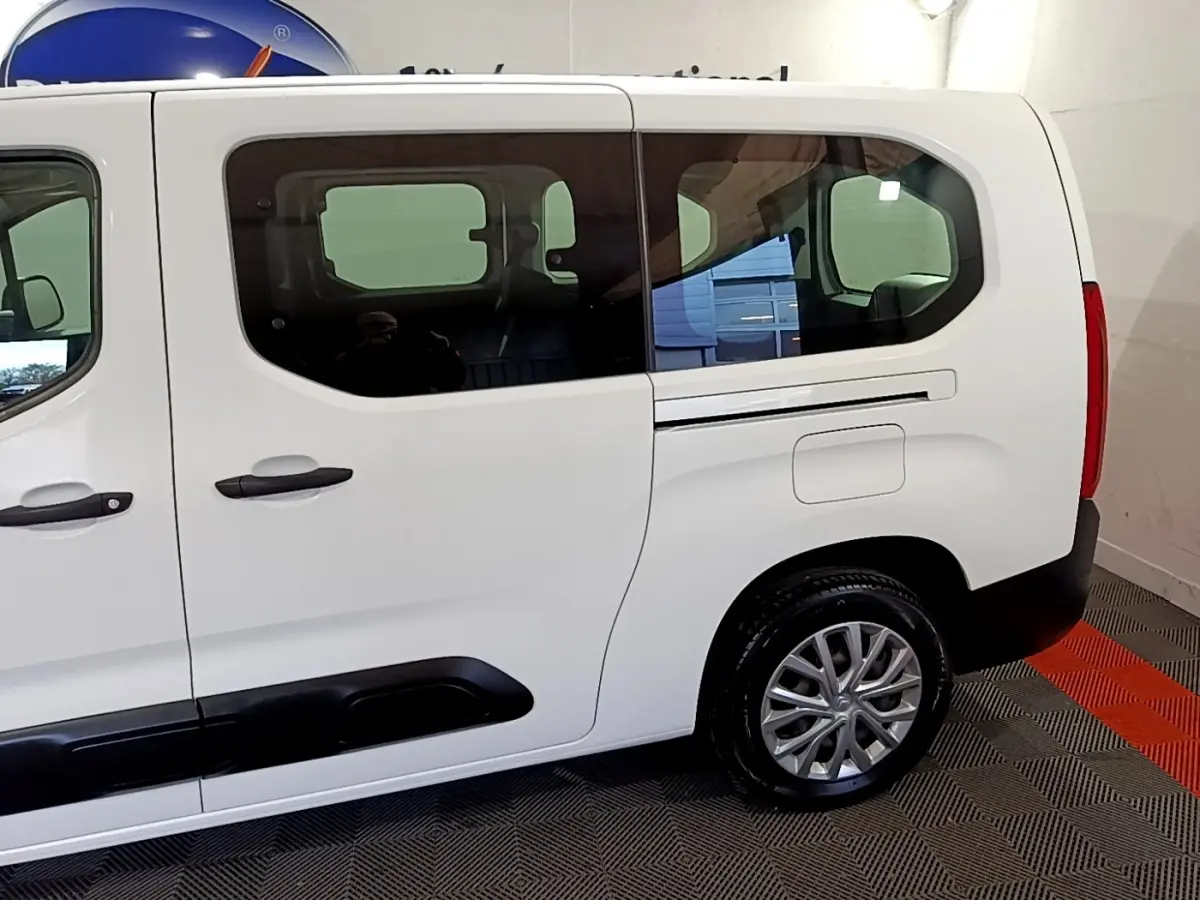 Vue latérale droite d'un Citroën Berlingo XL blanc avec fenêtres teintées et jantes alliage visibles.