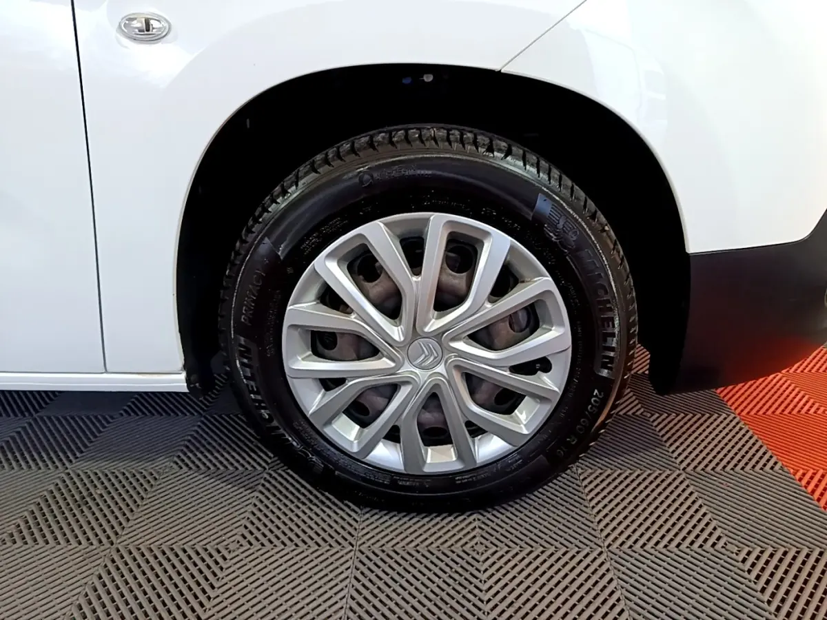 Gros plan sur la roue avant droite blanche d’un Citroën Berlingo XL 2019 avec jante argentée et pneu Michelin.