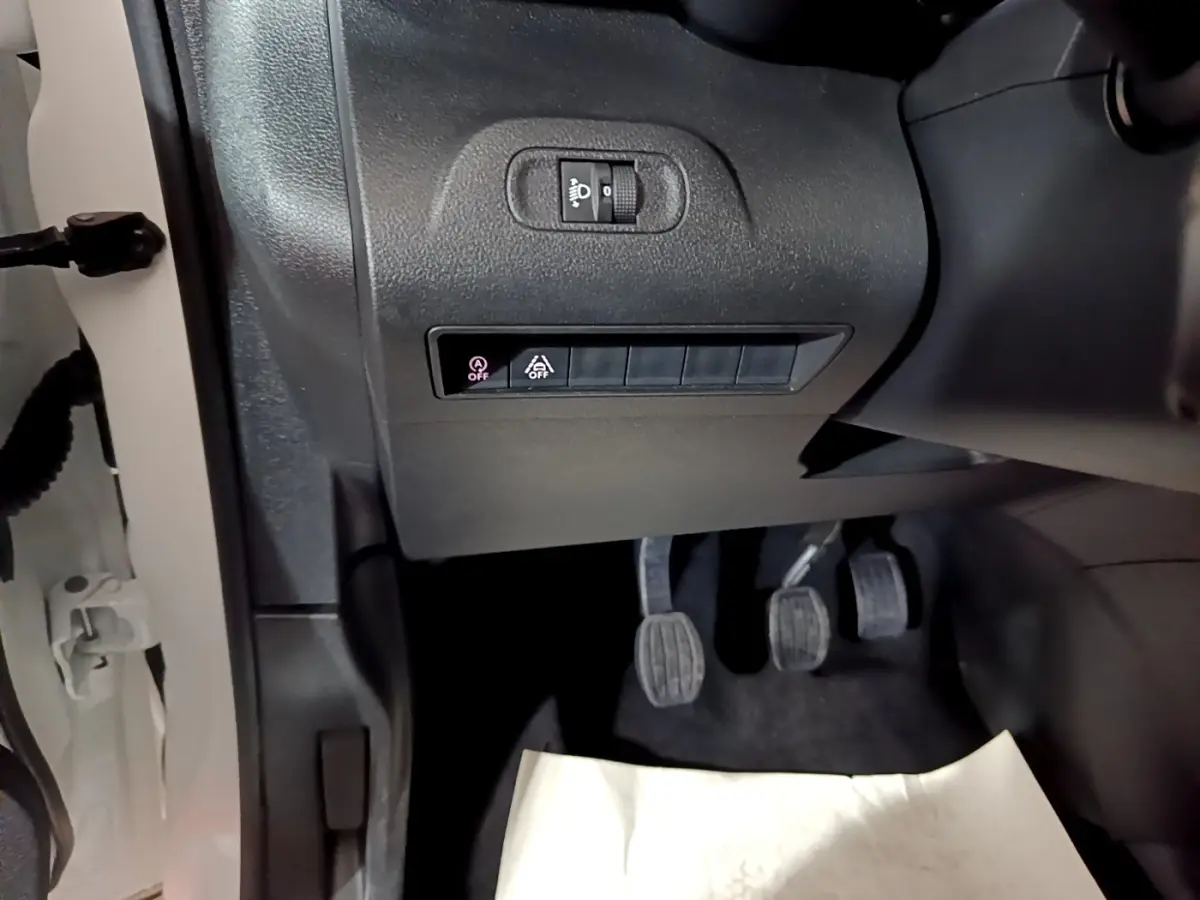 Vue intérieure côté conducteur du Citroën Berlingo blanc 2019, montrant les pédales et commandes sous le tableau de bord.