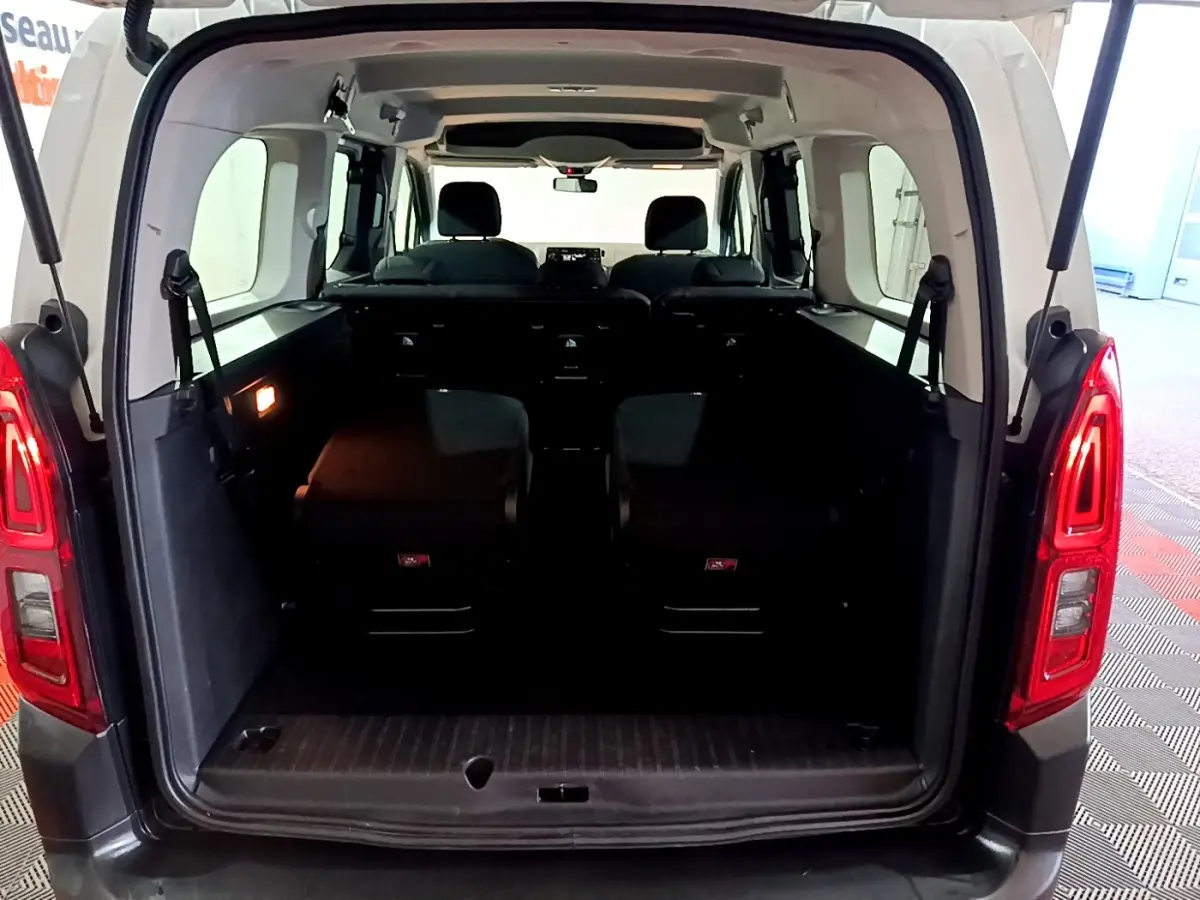 Vue arrière ouverte du Citroën Berlingo blanc XL montrant l'espace intérieur et les sièges rabattus.