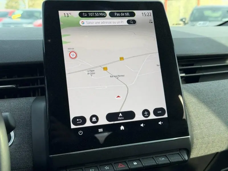 Vue rapprochée de l'écran tactile central du tableau de bord de la Renault Clio 1.6 E-Tech gris Rafale affichant la navigation GPS.