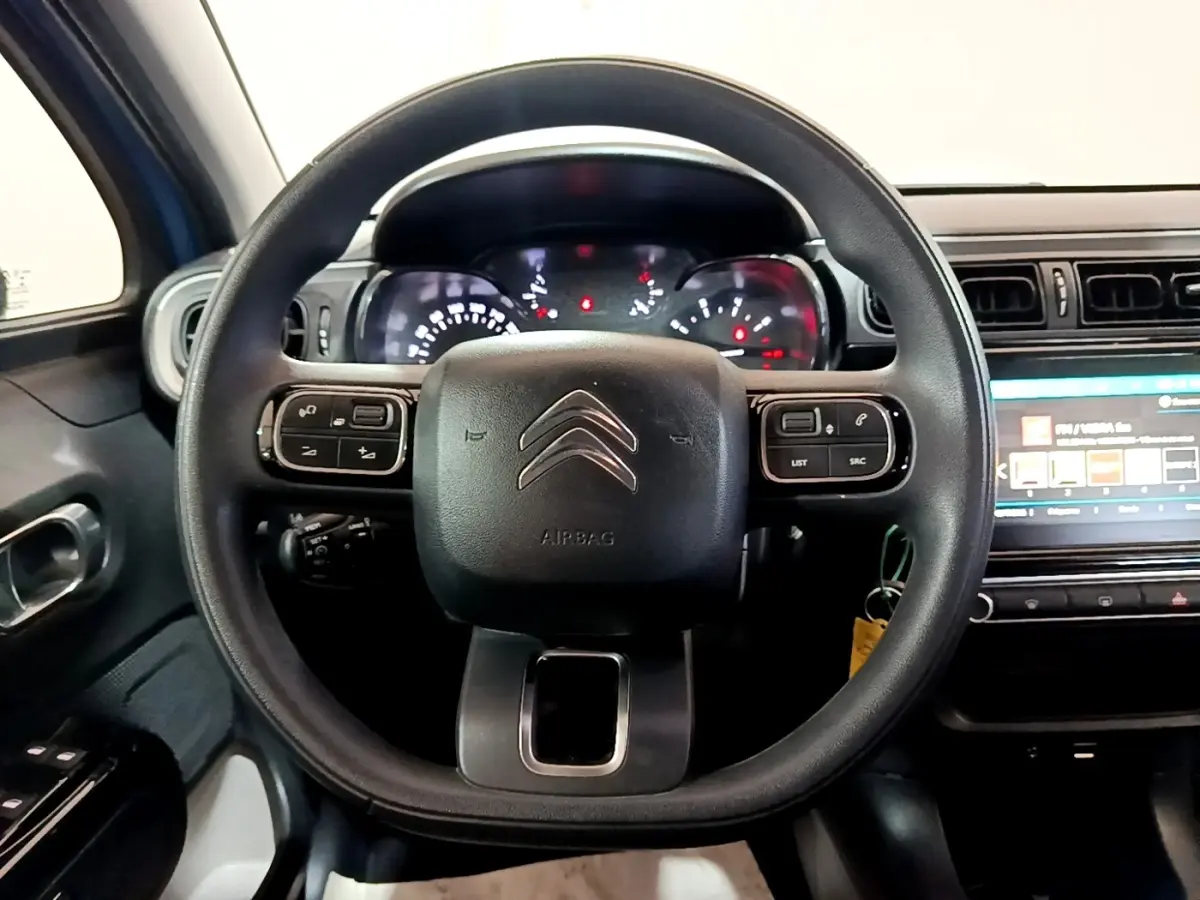 Vue rapprochée du volant multifonctions noir de la Citroën C3 avec tableau de bord et écran tactile visible à droite.