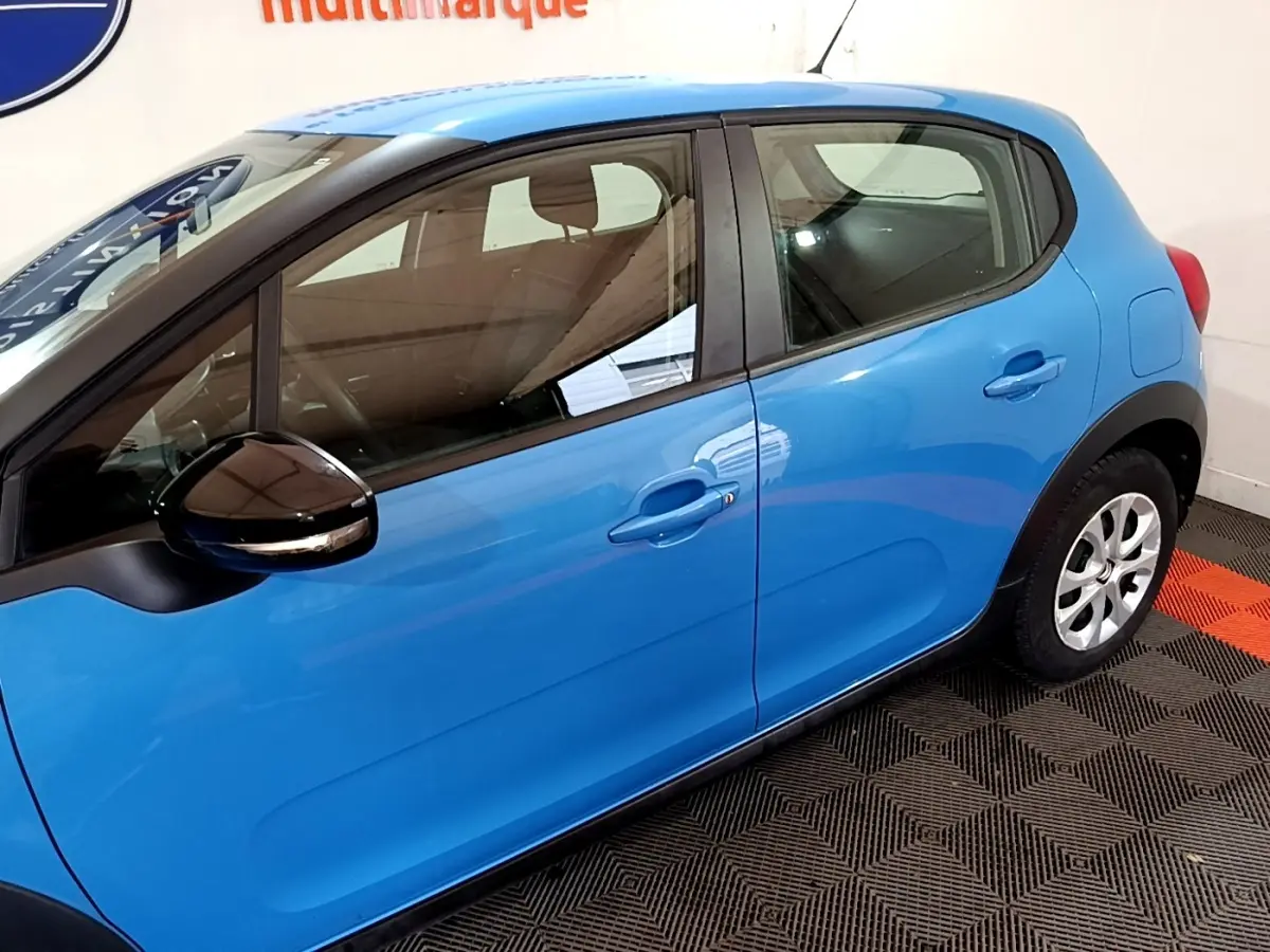 Vue latérale droite d'une Citroën C3 bleu vif avec rétroviseur noir et poignées de porte ton caisse.