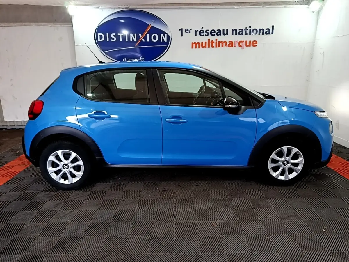 Vue de profil côté gauche d'une Citroën C3 bleu vif, avec jantes argentées et protections noires sur les passages de roues.