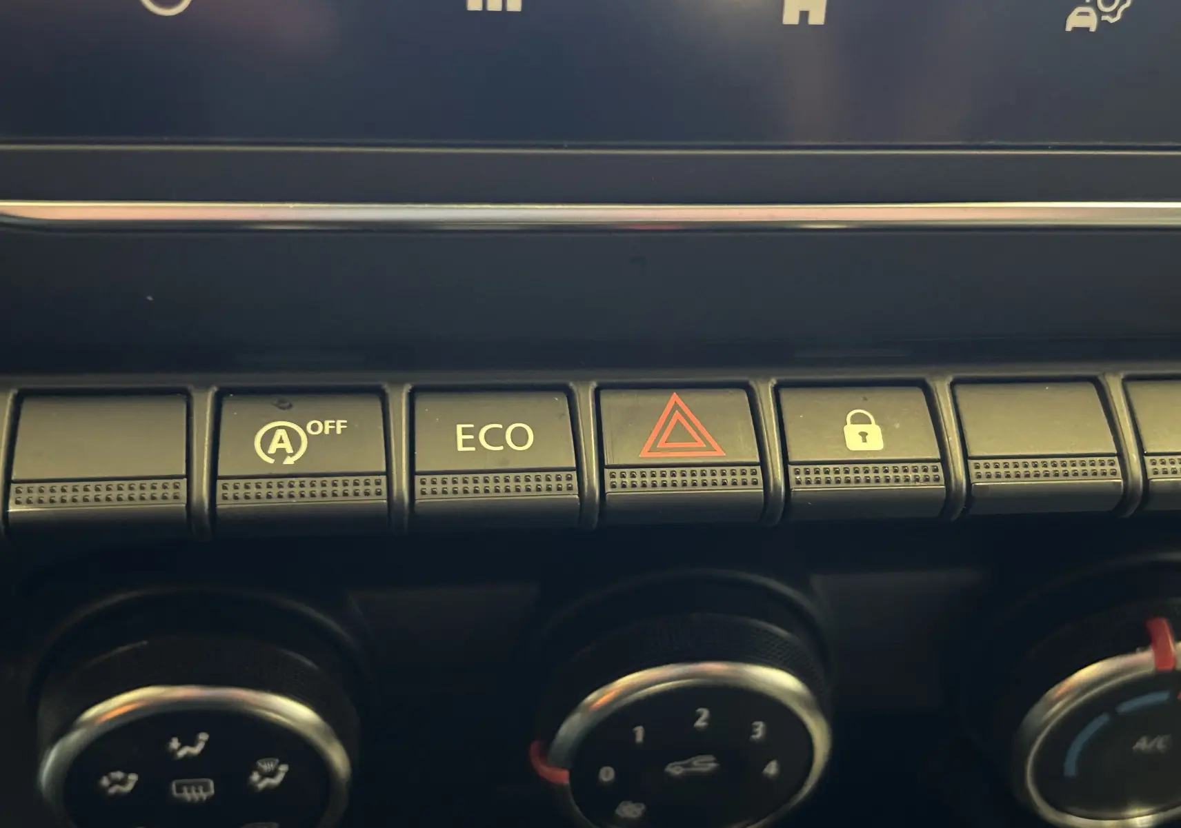 Gros plan sur les boutons de commande du tableau de bord de la Renault Clio V noire, avec touches ECO et alerte.