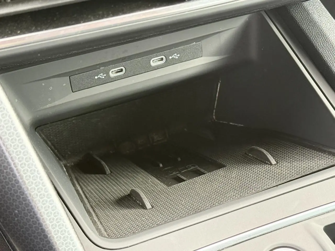 Gros plan sur la console centrale du SEAT Leon 2025, montrant les ports USB-C et le chargeur à induction noir.