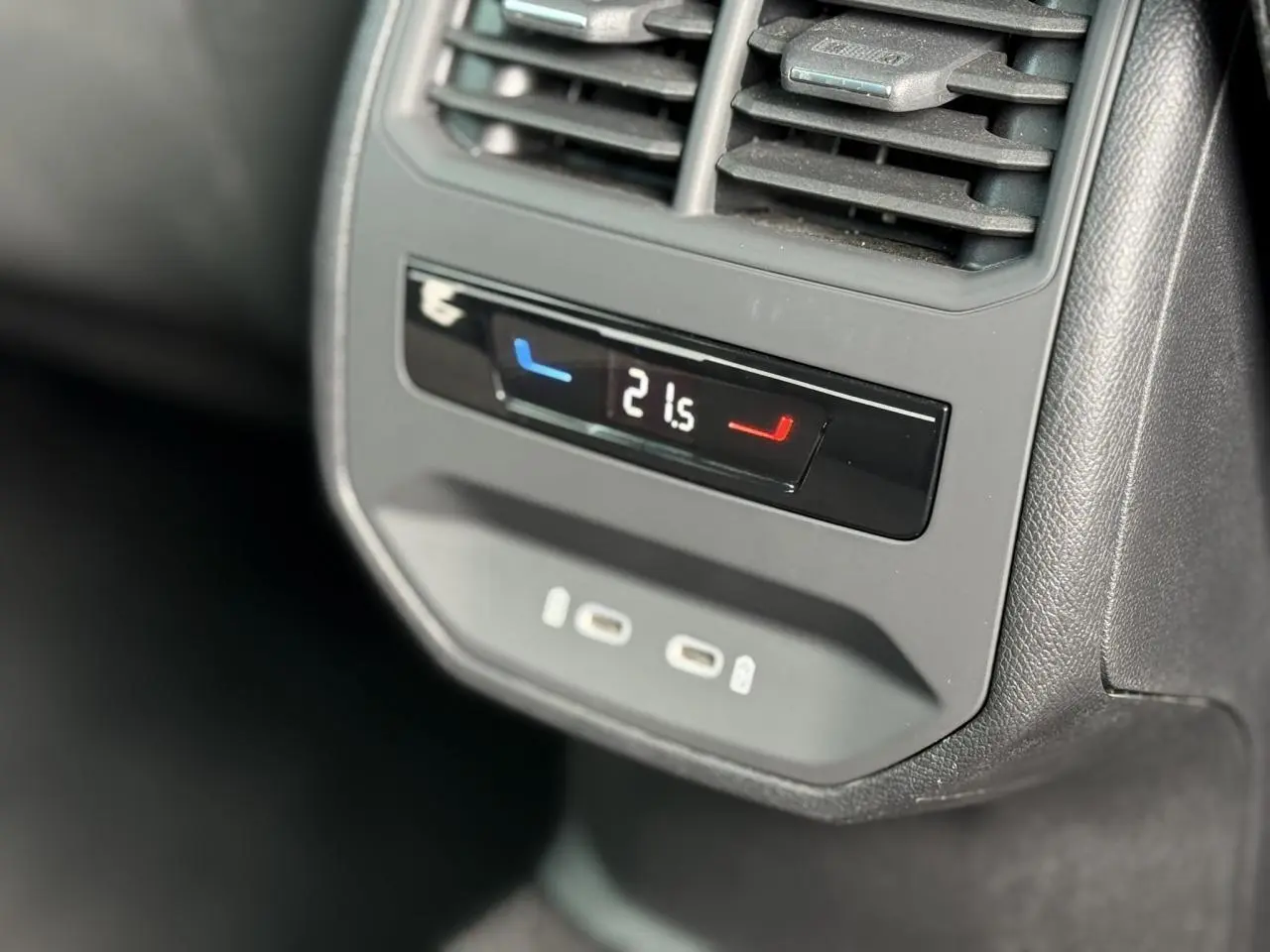 Détail du panneau de climatisation arrière avec affichage digital et ports USB-C dans une SEAT Leon blanche.