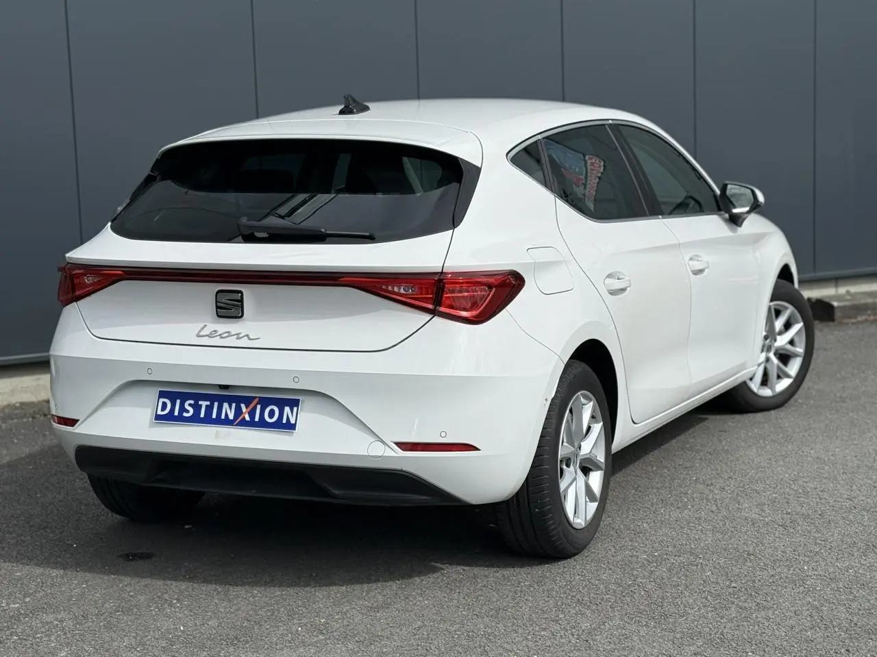 Vue 3/4 arrière droite d'une SEAT Leon blanche 2025 avec feux arrière LED et jantes alliage 16 pouces.