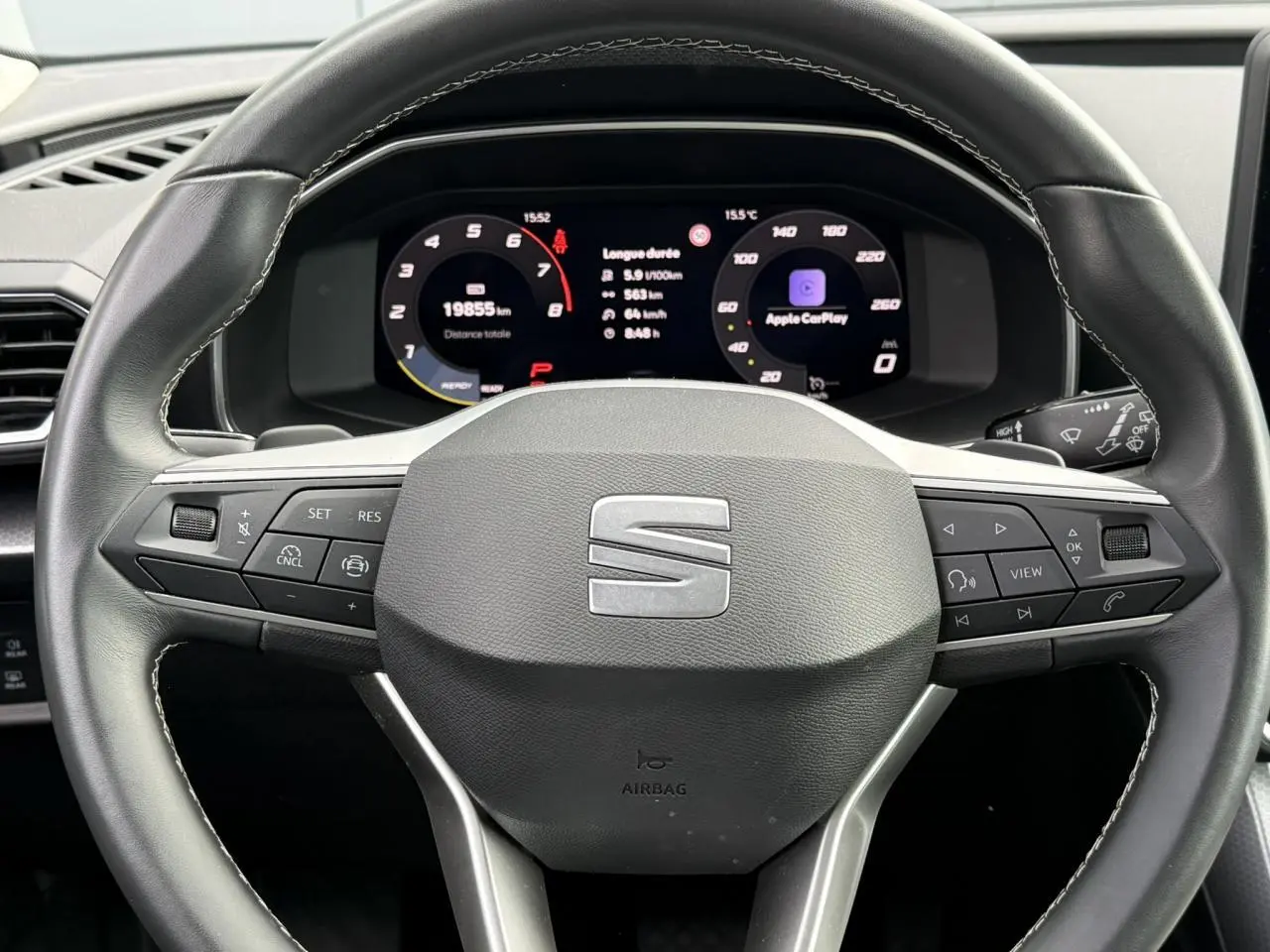 Vue rapprochée du volant cuir multifonction et du tableau de bord digital de la SEAT LEON blanche 2025.