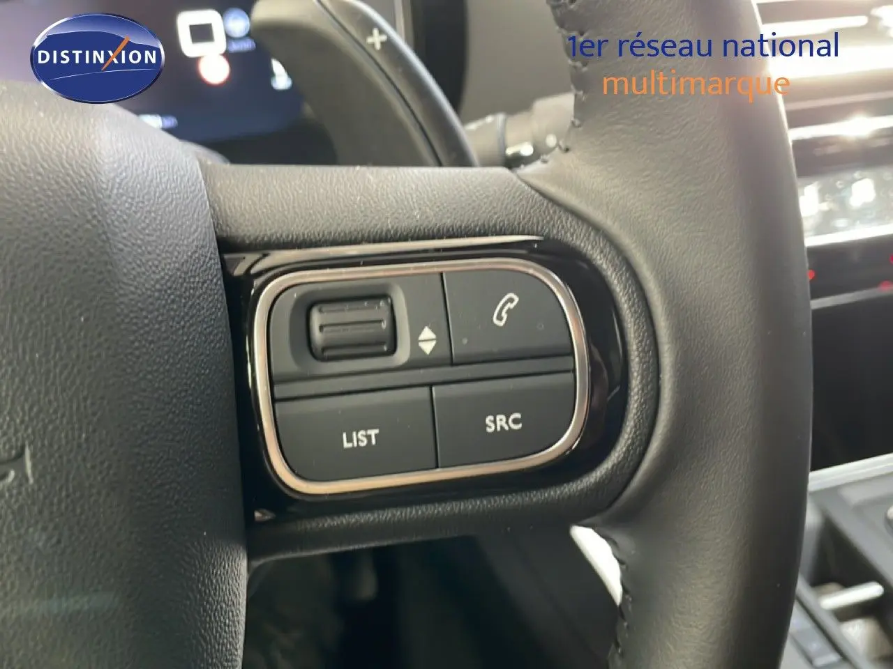 Gros plan sur les commandes au volant du Citroën C5 Aircross 2025, intérieur cuir noir avec boutons multifonctions.