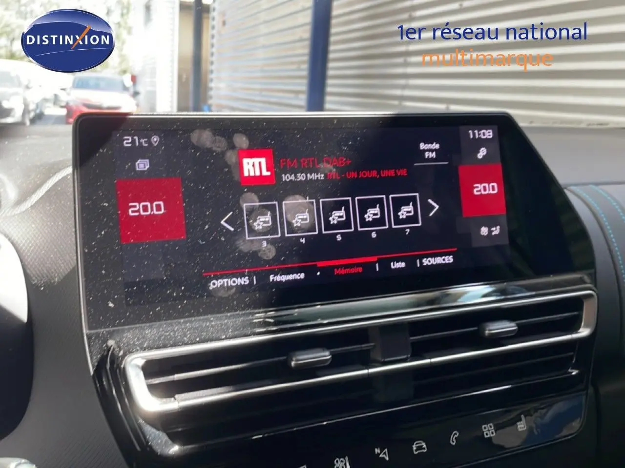 Vue rapprochée de l'écran tactile central du tableau de bord du Citroën C5 Aircross gris platinium, affichant la radio FM RTL.