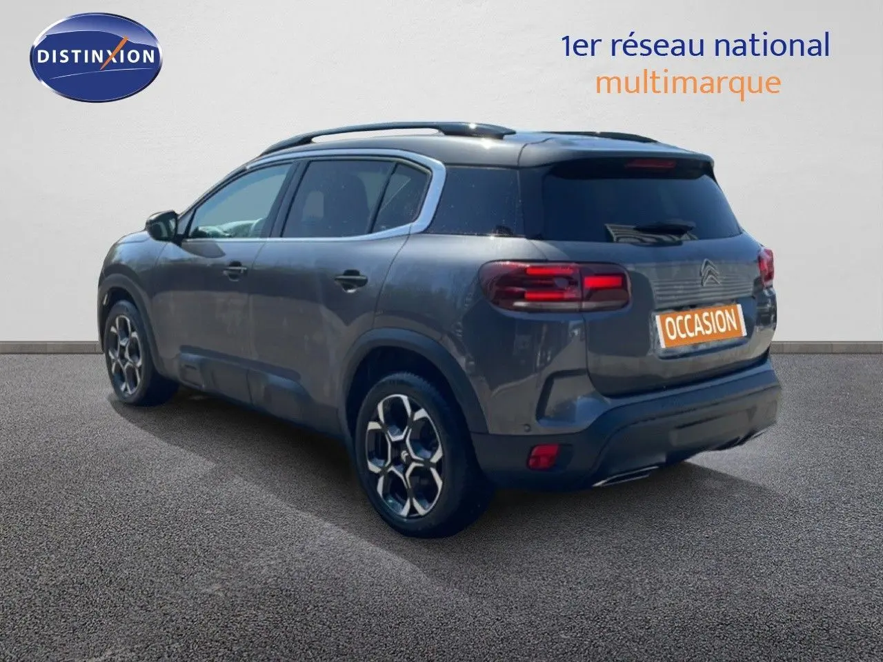Vue 3/4 arrière droite du Citroën C5 Aircross gris platinium métal avec jantes bi-ton et toit panoramique.