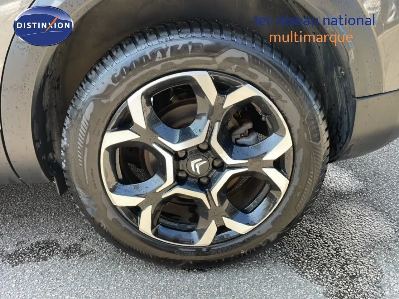 Gros plan sur la roue avant gauche du Citroën C5 Aircross gris platinium métal avec jante alliage noire et argentée.